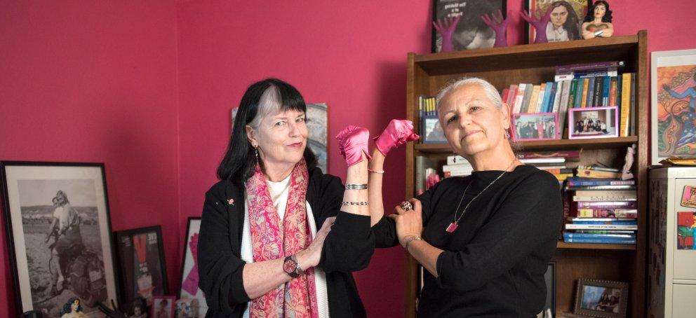 两位女性和性别研究教授举起拳头以示权力