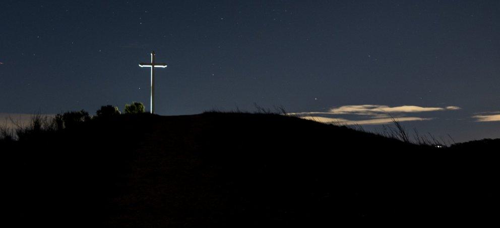 Cross on a hill, night sky in the background